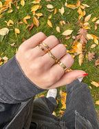 Stylish Elevated Faith Christian Jewelry rings on hand, surrounded by autumn leaves