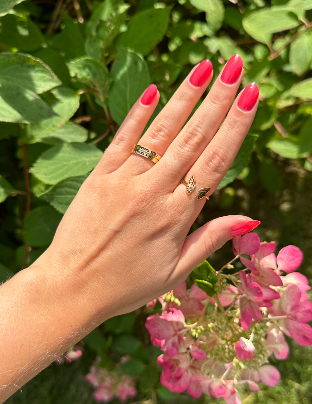 Elegant Elevated Faith Ring on a Hand, Surrounded by Pink Flowers, Perfect Christian Jewelry