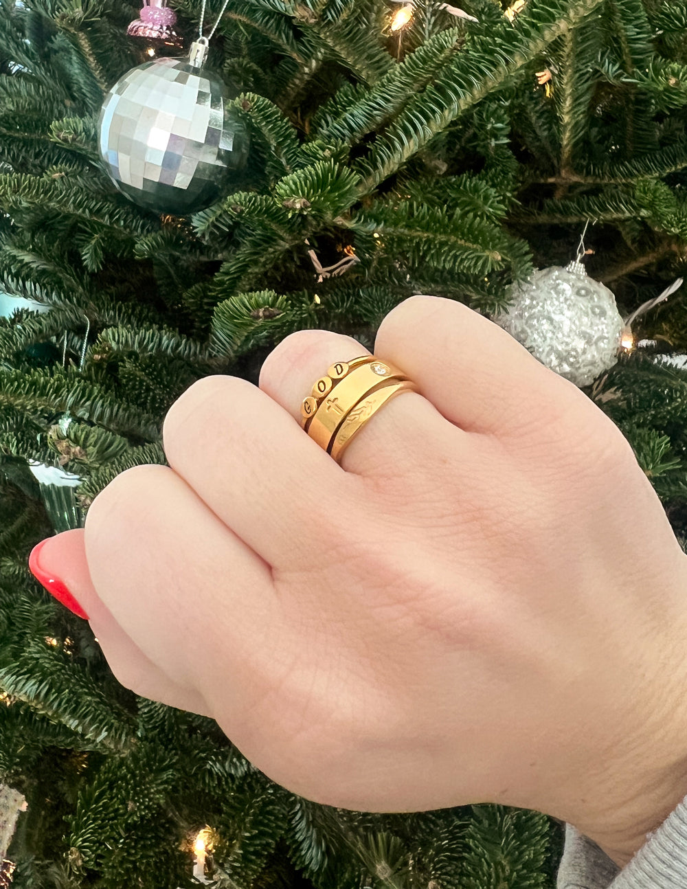Elevated Faith Christian Jewelry Gold Ring Stack on Hand Celebrating Faith in Festive Setting