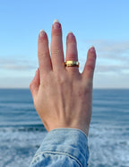 Elegant Elevated Faith Ring on hand against ocean backdrop, showcasing stylish Christian Jewelry