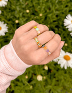 Various colorful rings displayed on a hand, highlighting elevated Christian Jewelry for fashionable faith expressions