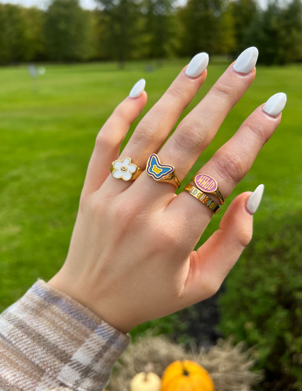 Elevated Faith Christian Jewelry ring in gold with butterfly and flower design on a hand outdoors