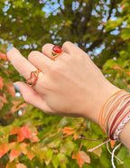 Elevated Faith Christian Jewelry featuring stylish rings on a hand with colorful autumn leaves