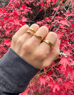 Three elegant gold rings displayed on a hand, perfect for showcasing Christian jewelry