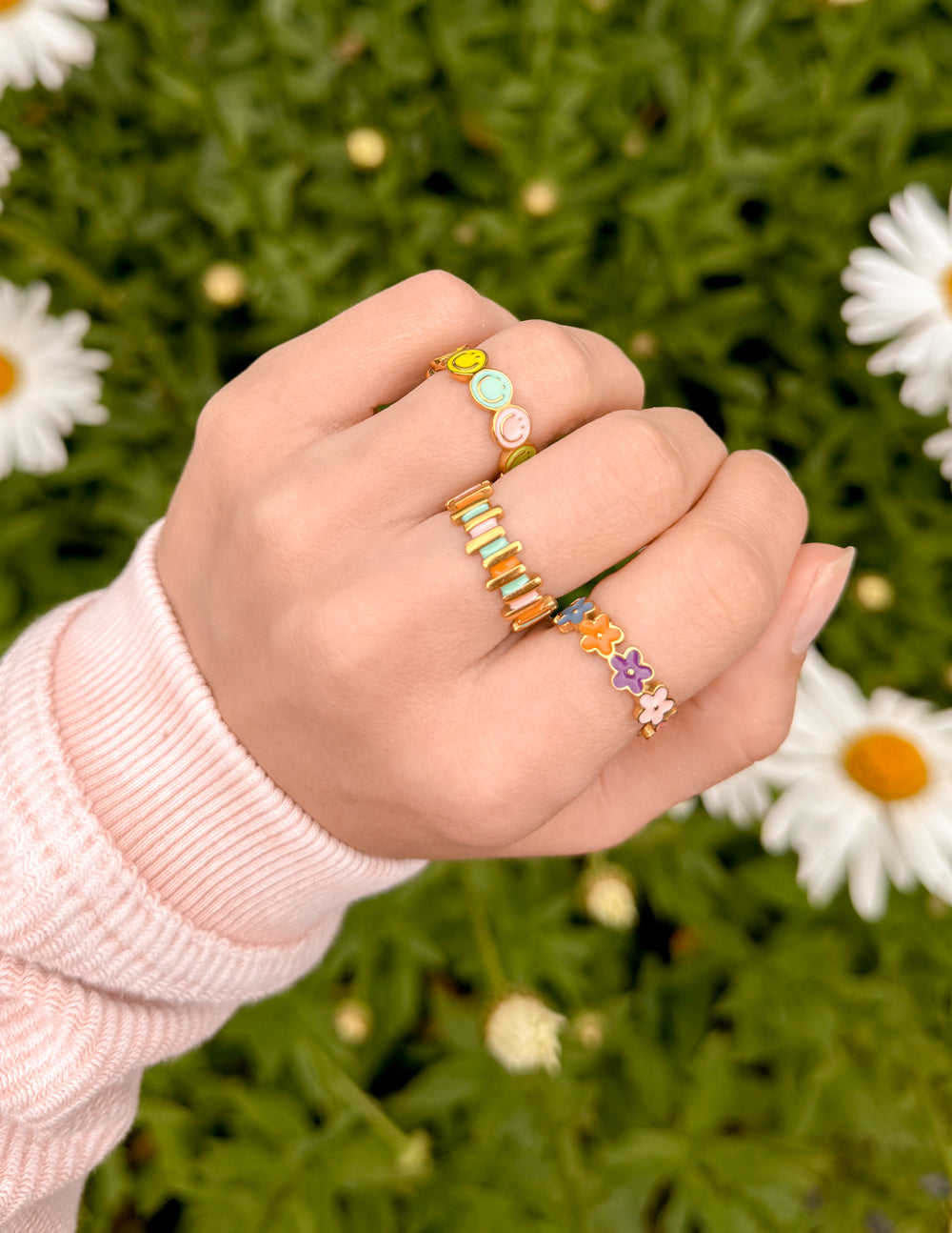 Collection of Elevated Faith Christian Jewelry rings in various colors and designs worn on a hand