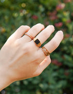 Three elegant Elevated Faith rings showcasing unique designs as Christian Jewelry on a hand outdoors