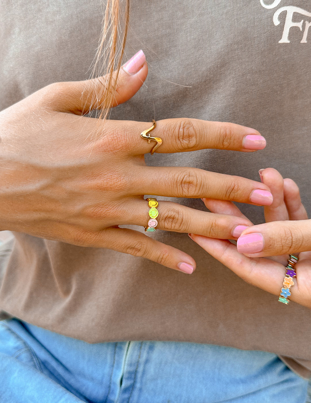 Gold and colorful Elevated Faith rings worn on fingers, showcasing stylish Christian Jewelry