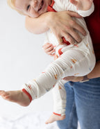 Baby wearing a cozy onesie from Elevated Faith, featuring Christian Kids Apparel with playful designs