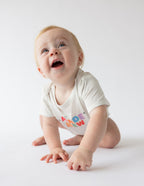 Baby crawling in Elevated Faith onesie that promotes Christian Kids Apparel with colorful design