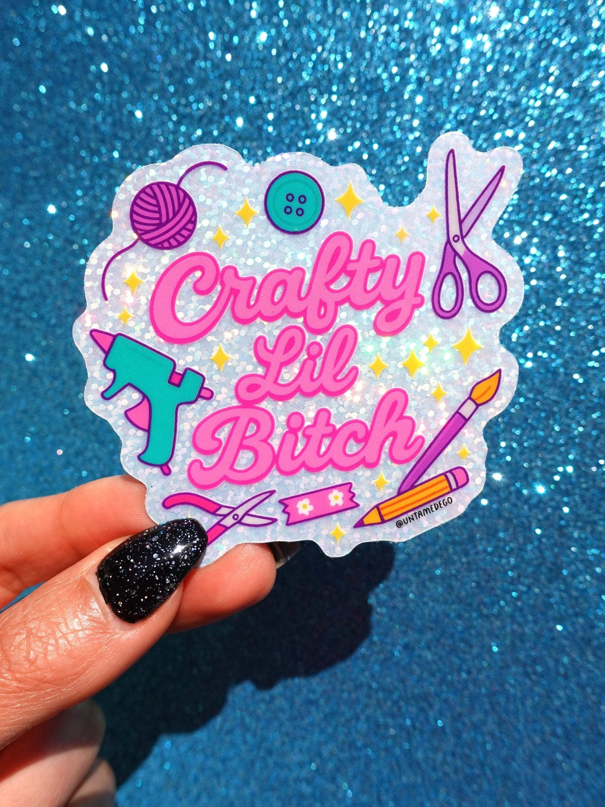 Funny Die-cut glitter sticker with pink “Crafty Lil Bitch” lettering and scissors with yarn icon.