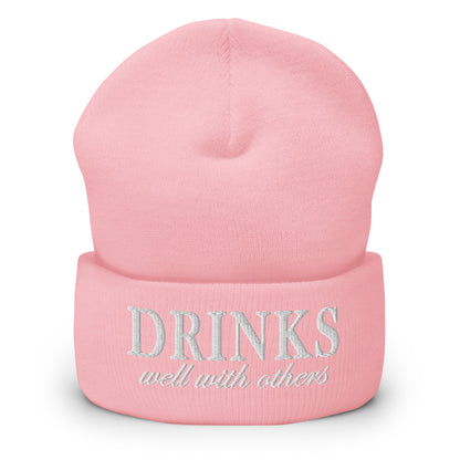 Baby pink knit cuffed beanie with embroidered 'DRINKS' and 'well with others'