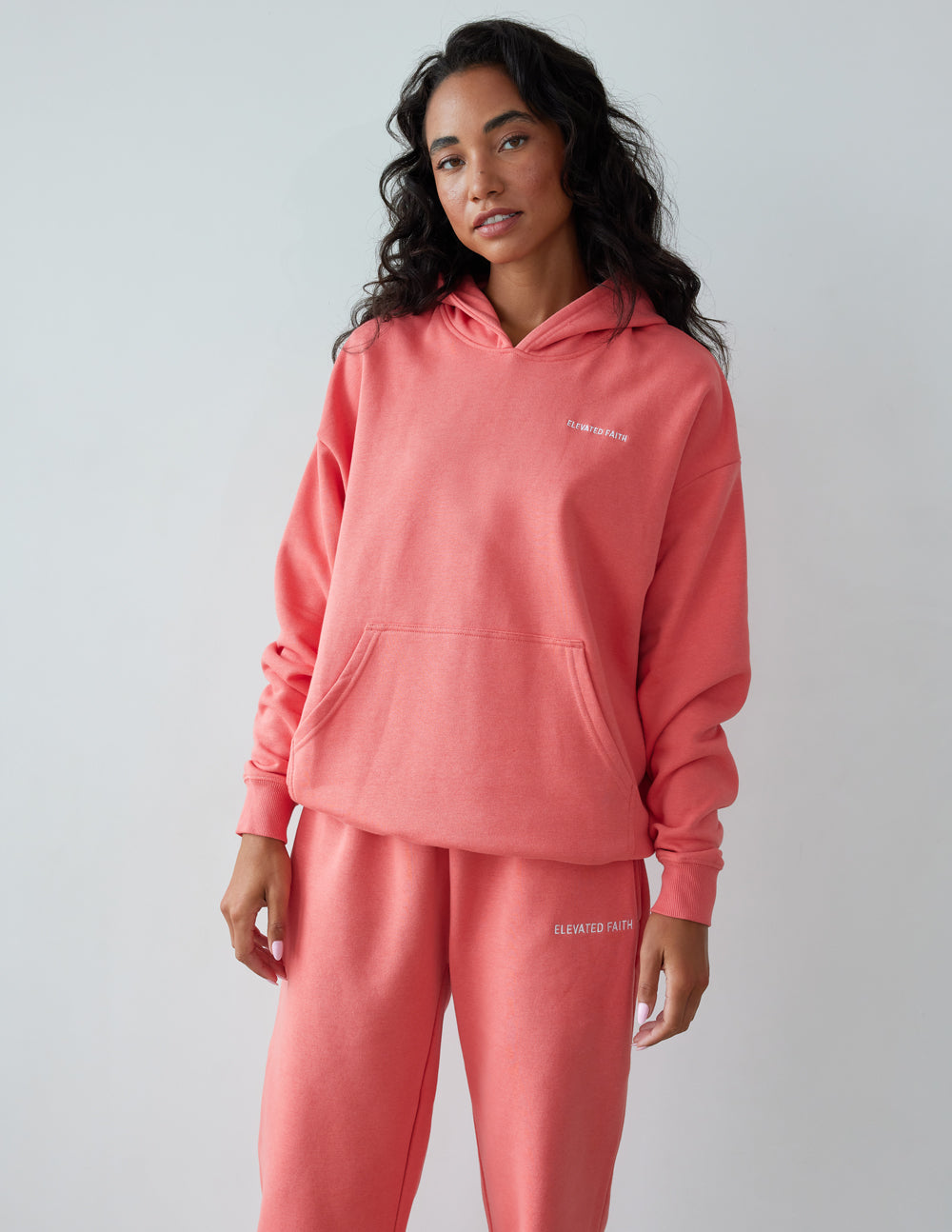 Elevated Faith Christian Hoodie in coral color featuring a front pocket and a comfortable fit