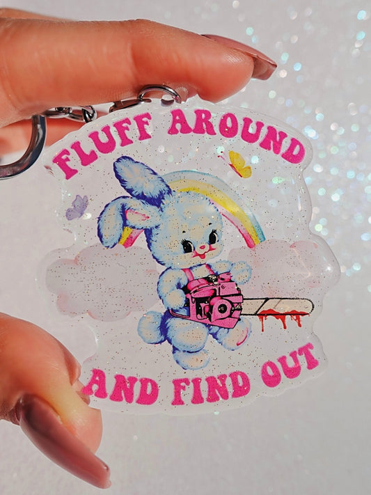 Funny Acrylic keychain with blue bunny holding a cart, rainbow graphic and 'Fluff Around...' text