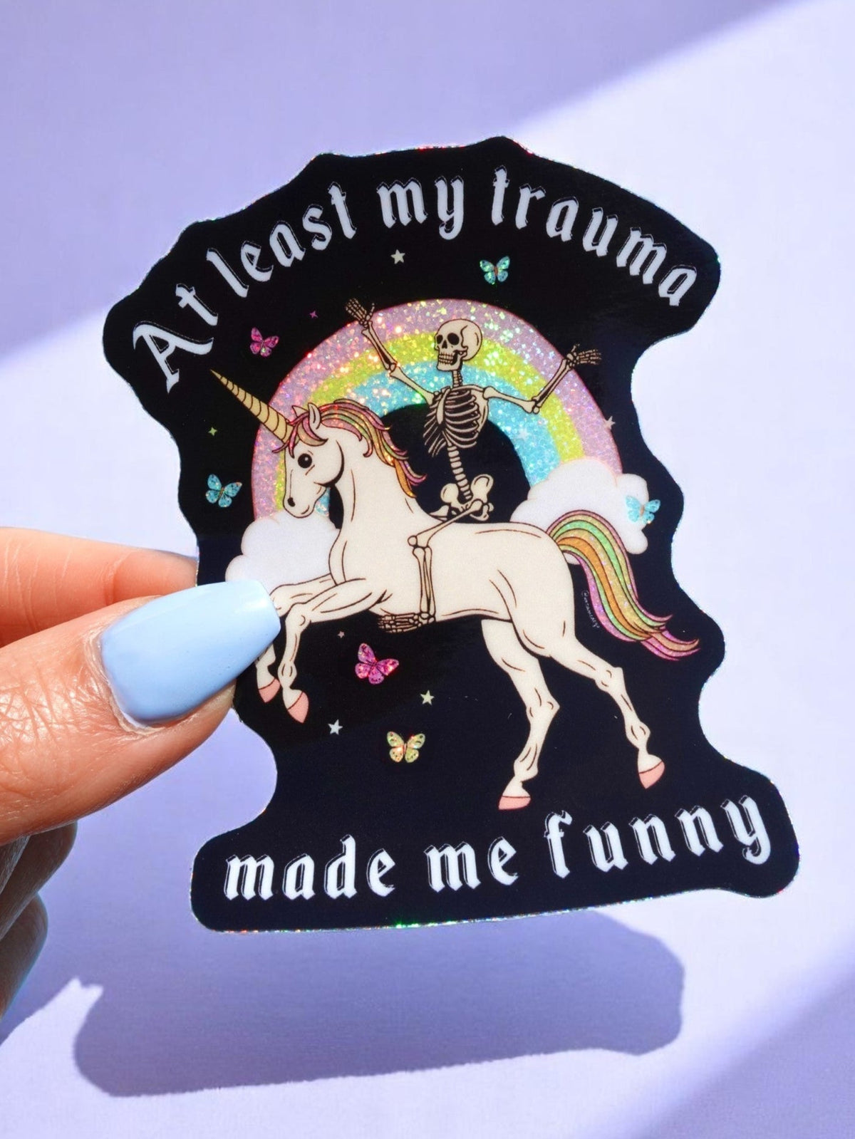 Black unicorn sticker with rainbow crescent, skeleton rider, and 'made me funny' text