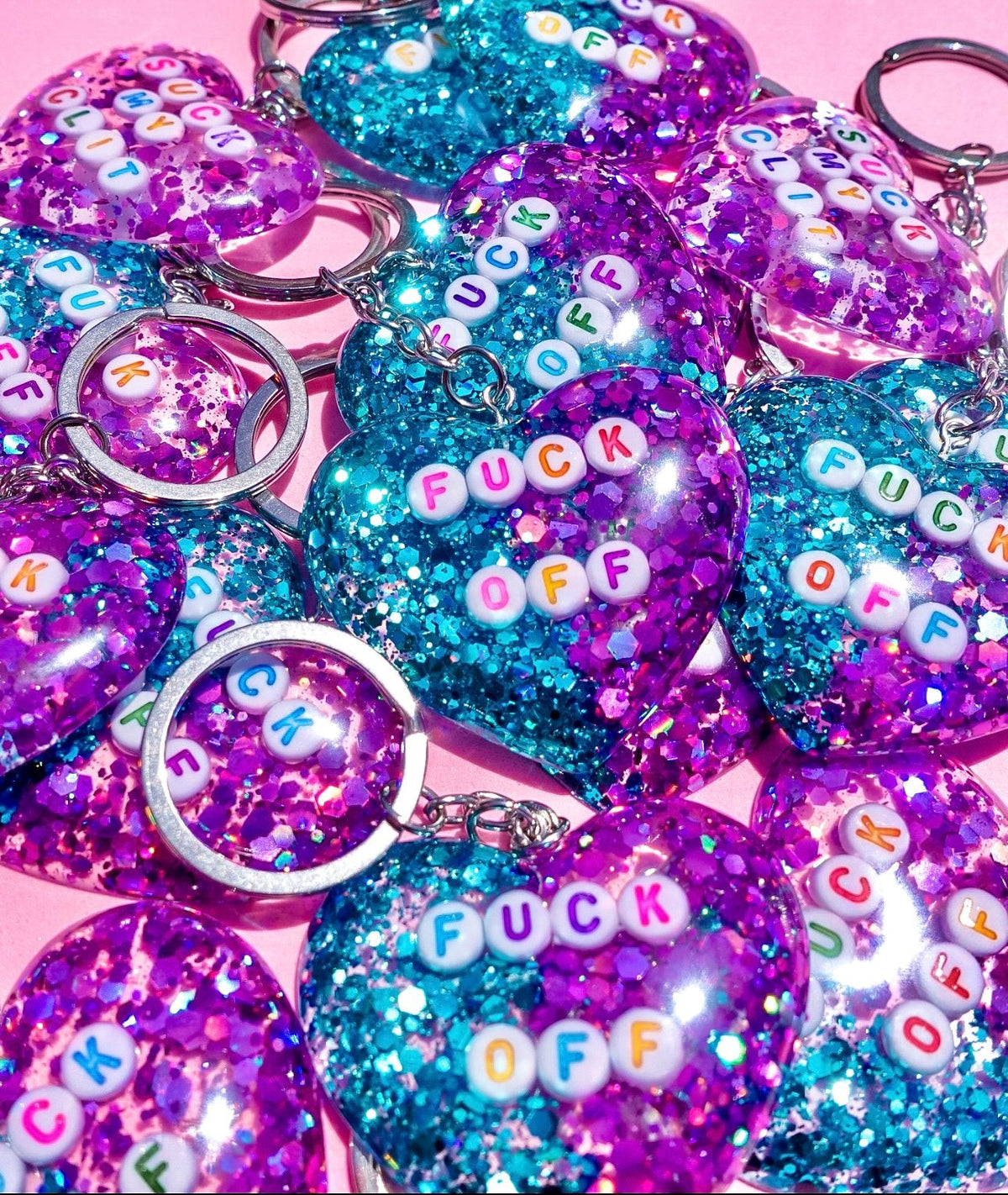 Funny Assorted glitter heart keychains with “FUCK OFF” letters in purple and teal colors