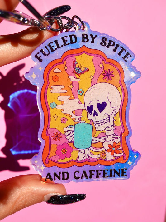 Funny Rainbow keychain with skull graphic and “Fueled by Spite and Caffeine” text