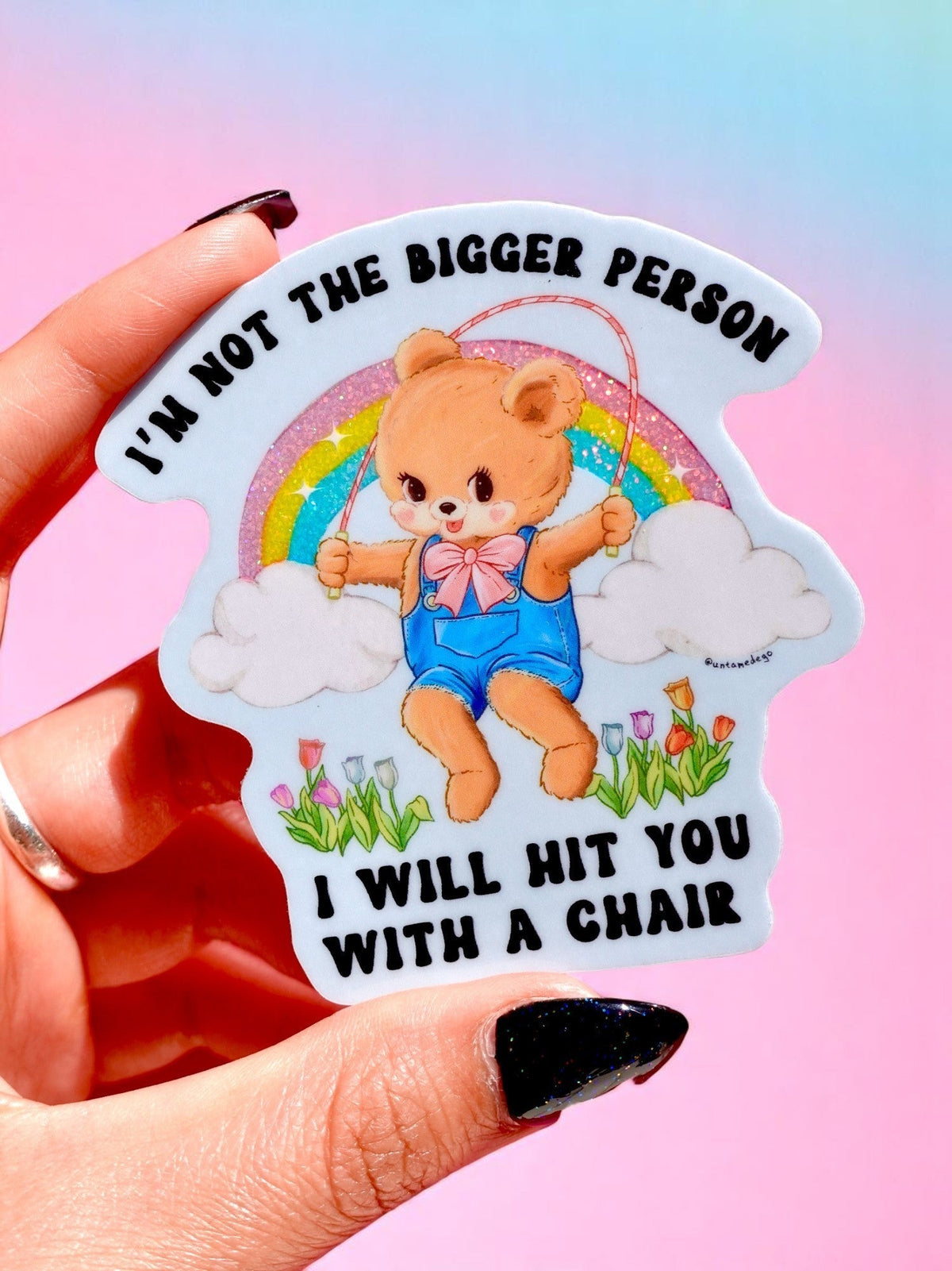 Funny Teddy bear cartoon sticker with rainbow and clouds, arched black text and flowers