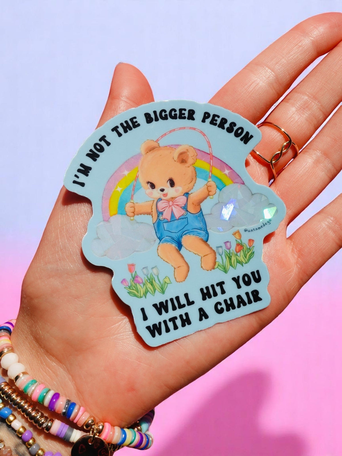Funny Teddy bear cartoon sticker with rainbow and clouds, arched black quote