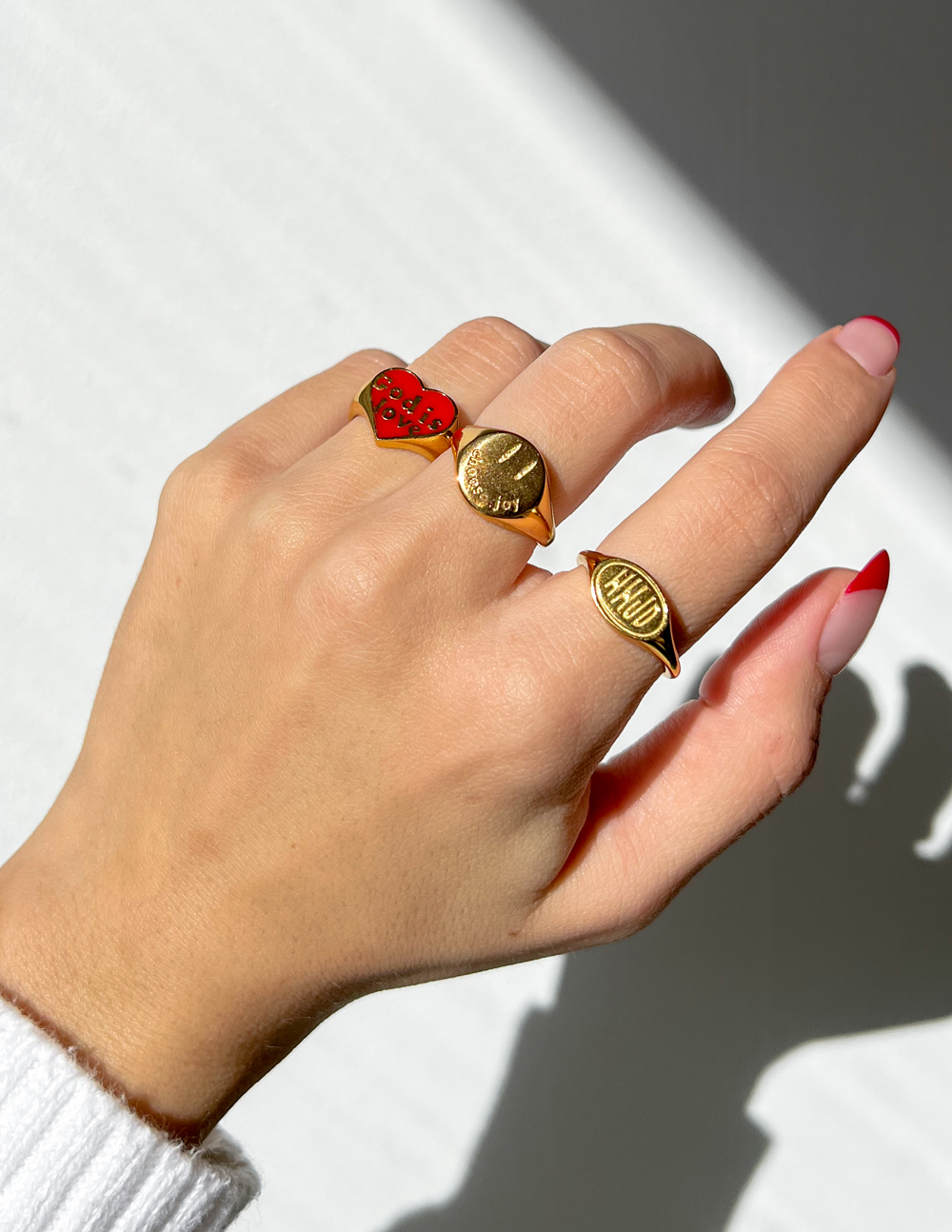 Gold Elevated Faith ring set featuring Christian Jewelry with heart and hand designs on a model's hand