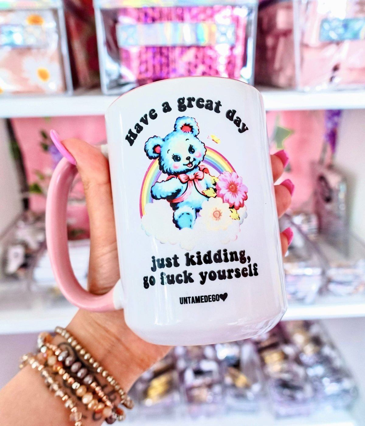 Funny "Have A Great Day Just Kidding" — White mug with pink handle and bear illustration with humorous text, in hand