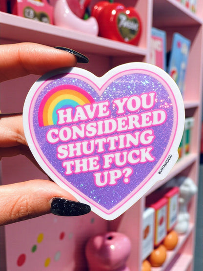 Funny Glitter heart sticker held by hand, rainbow text 'Have you considered shutting the FUCK up?'