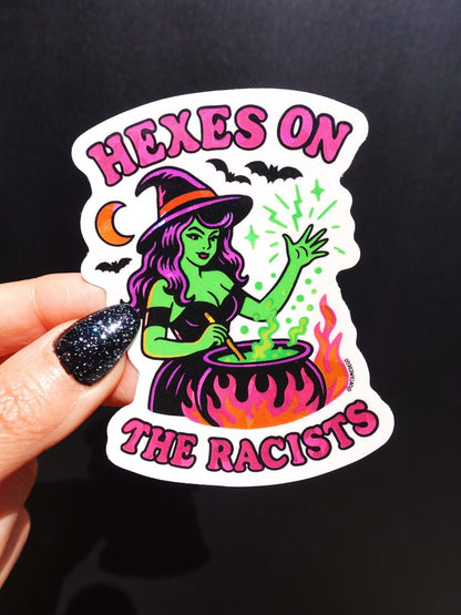 Funny Halloween vinyl sticker with green witch and cauldron, text HEXES ON THE RACISTS