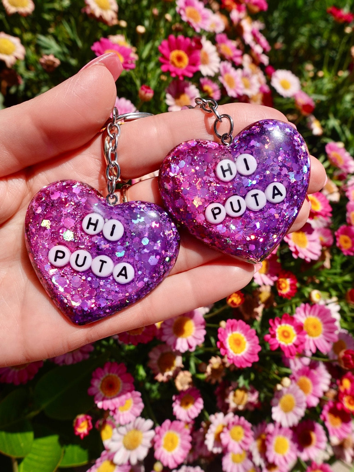 Funny Pair of purple glitter heart keychains with metal rings and “HI PUTA” letters
