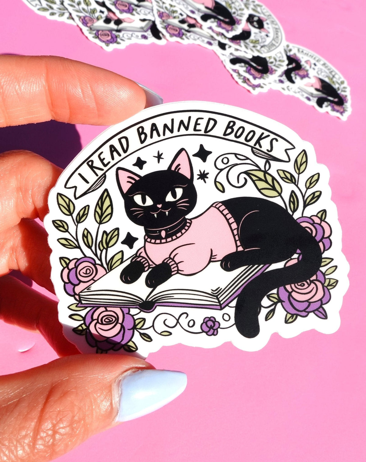 Funny Cat reading open book sticker with floral wreath and 'I Read Banned Books' text