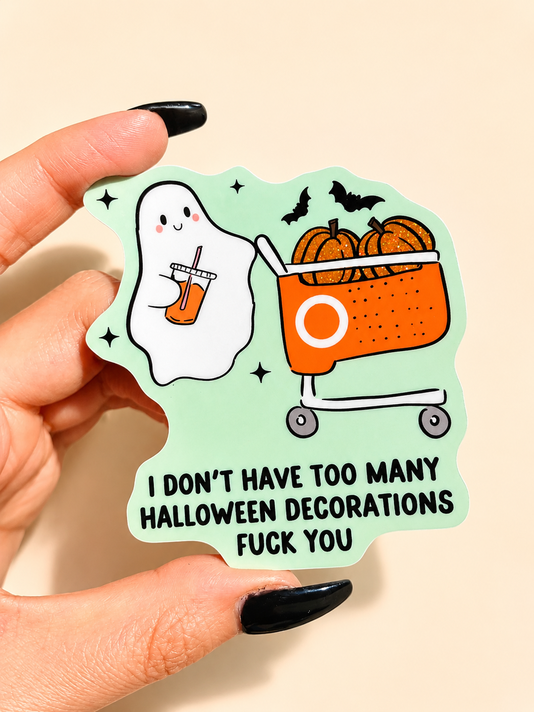 Funny Halloween ghost sticker held in hand: mint outline, pumpkin cauldron, bats, 'FUCK YOU' text