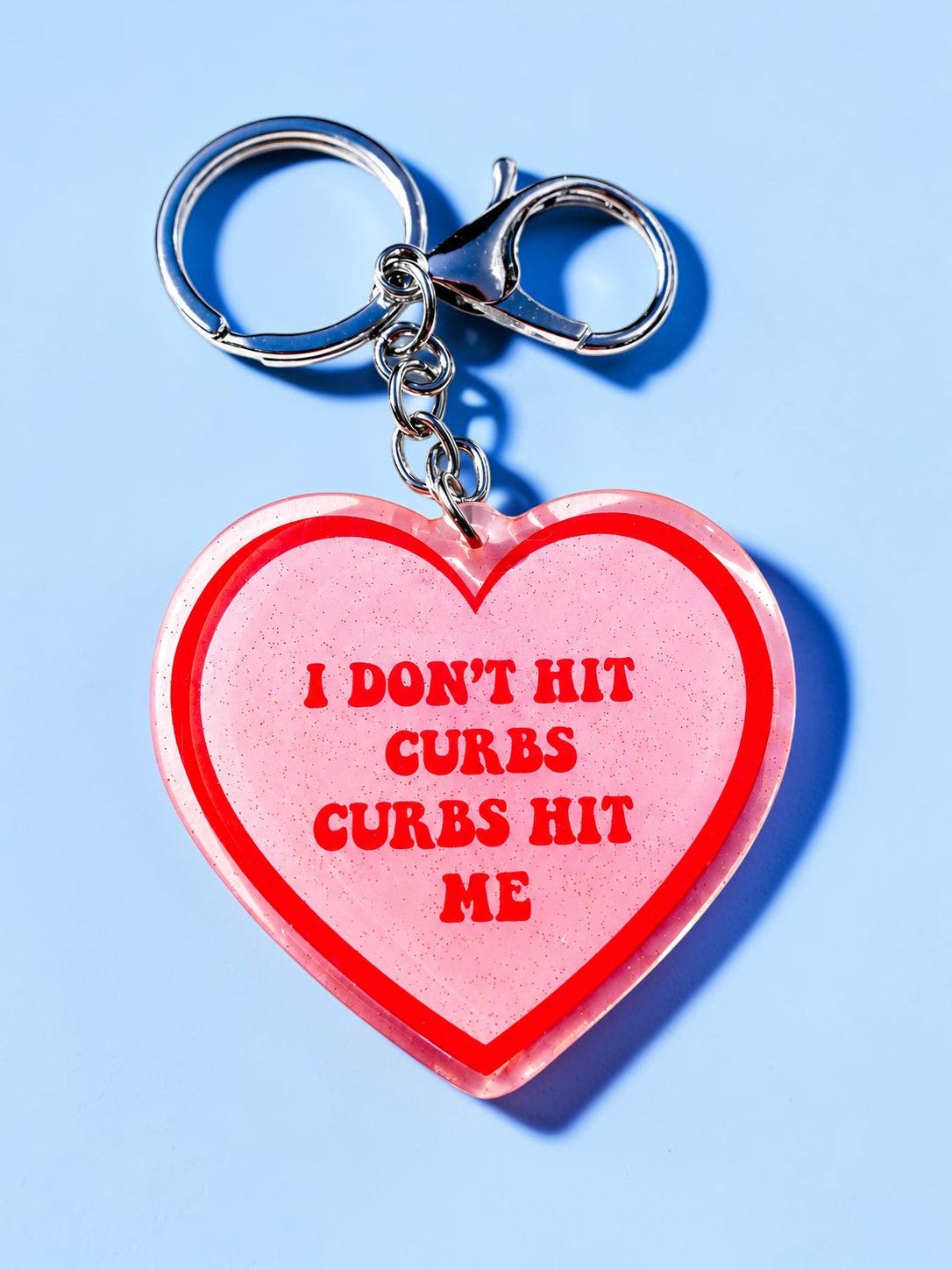 Funny Red holographic heart keychain with split ring and lobster clasp, 'I DON'T HIT CURBS CURBS HIT ME'.