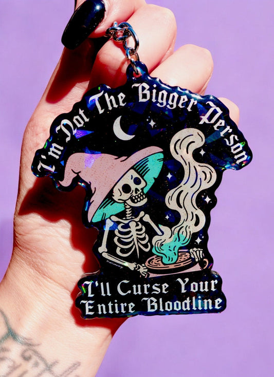 Funny Gothic skull keychain with teal accents and 'Curse Your Entire Bloodline' lettering