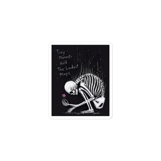 3 x 3 inch 'Tiny Moments' goth sticker featuring a kneeling skeleton holding a tiny pink flower on a black background, with the words "Tiny moments hold the loudest magic"