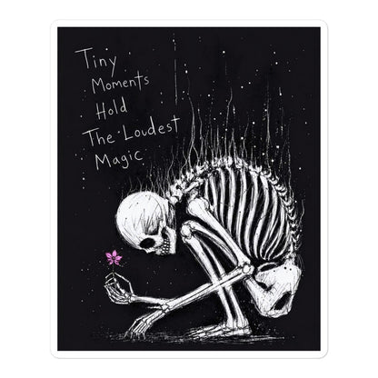 5.5 x 5.5 inch 'Tiny Moments' goth sticker featuring a kneeling skeleton holding a tiny pink flower on a black background, with the words "Tiny moments hold the loudest magic"