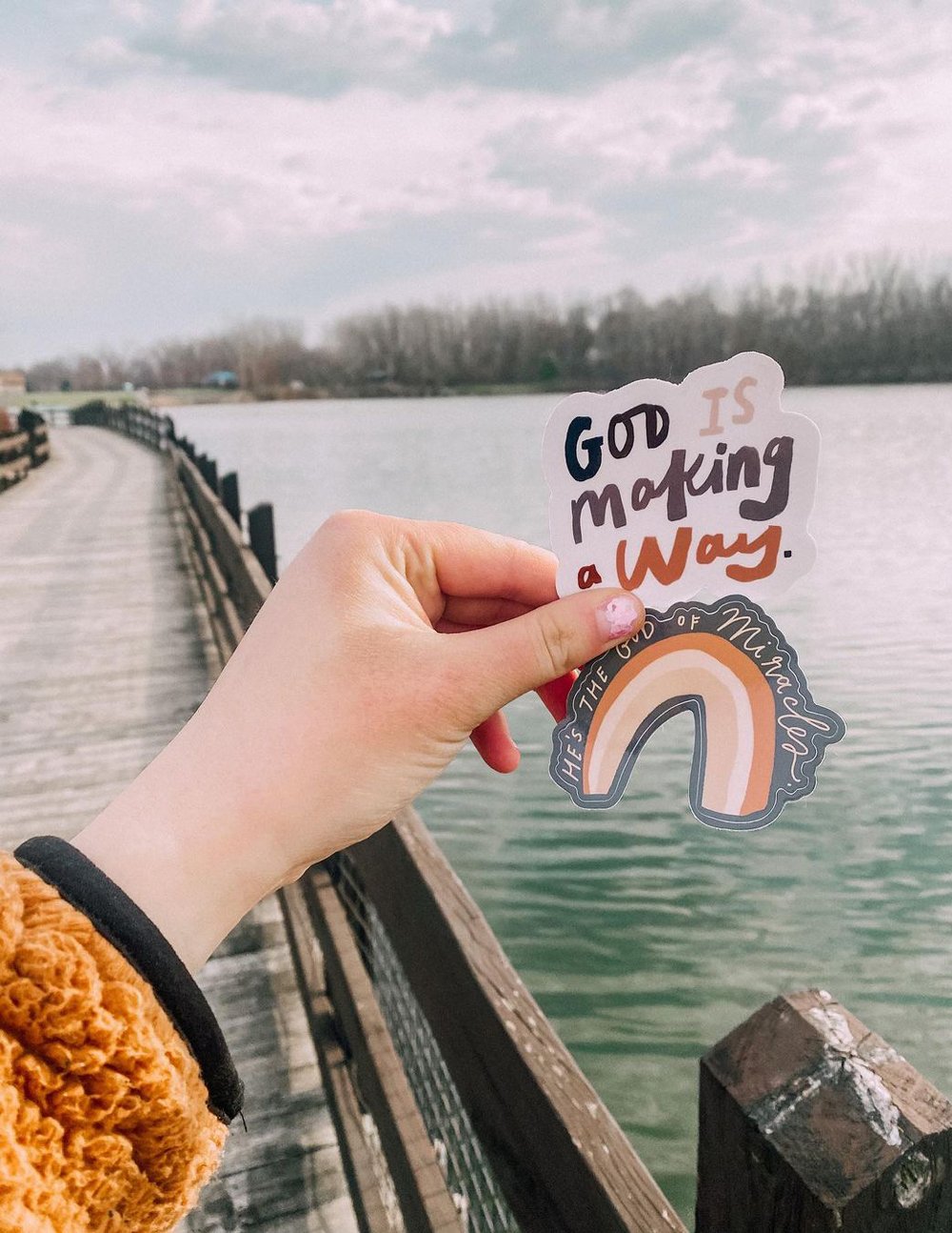 Christian Stickers featuring a colorful rainbow and uplifting text against a scenic backdrop