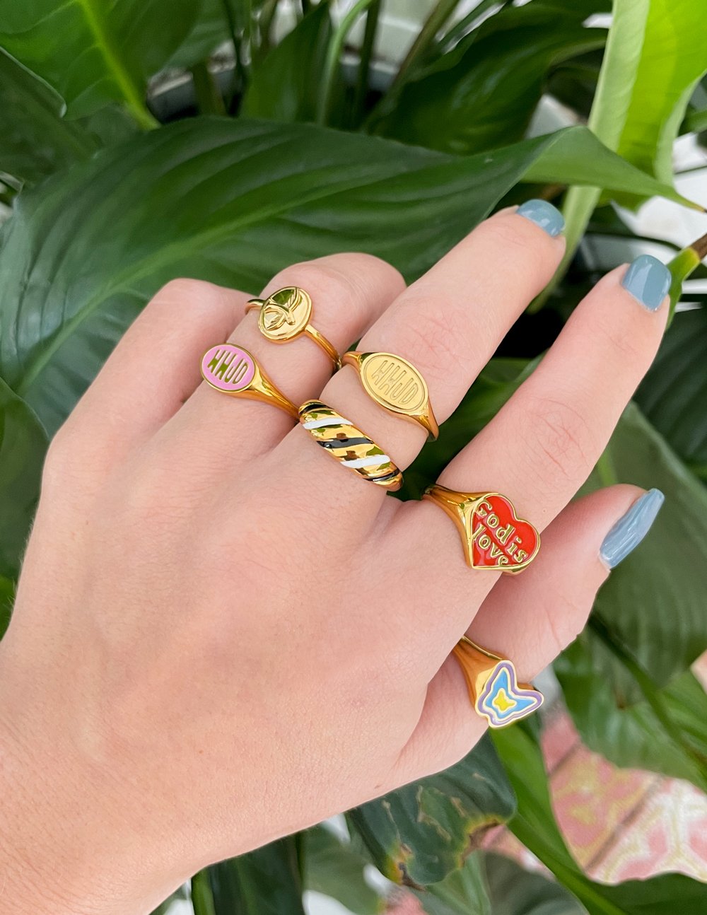 Assorted Elevated Faith rings in gold, showcasing colorful designs, perfect for Christian jewelry enthusiasts
