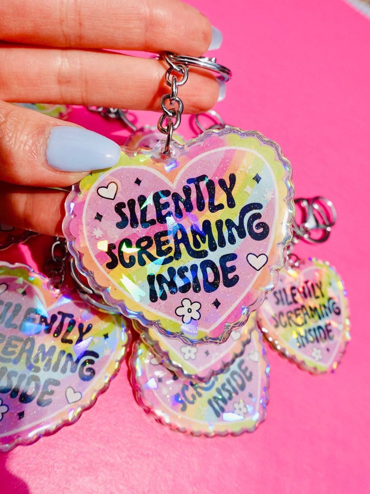 Funny Holographic heart keychain on a metal ring, showing 'Silently Screaming Inside'