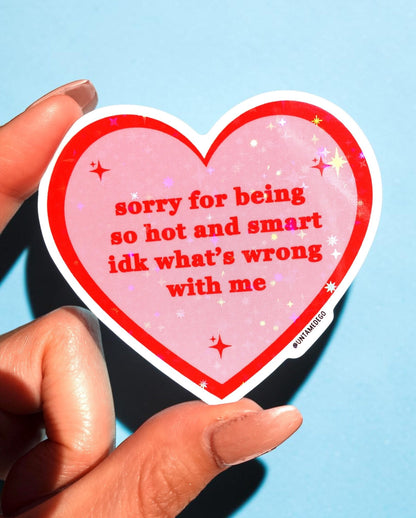 Funny Heart-shaped red/pink sticker with white border, starry text; held by two fingers