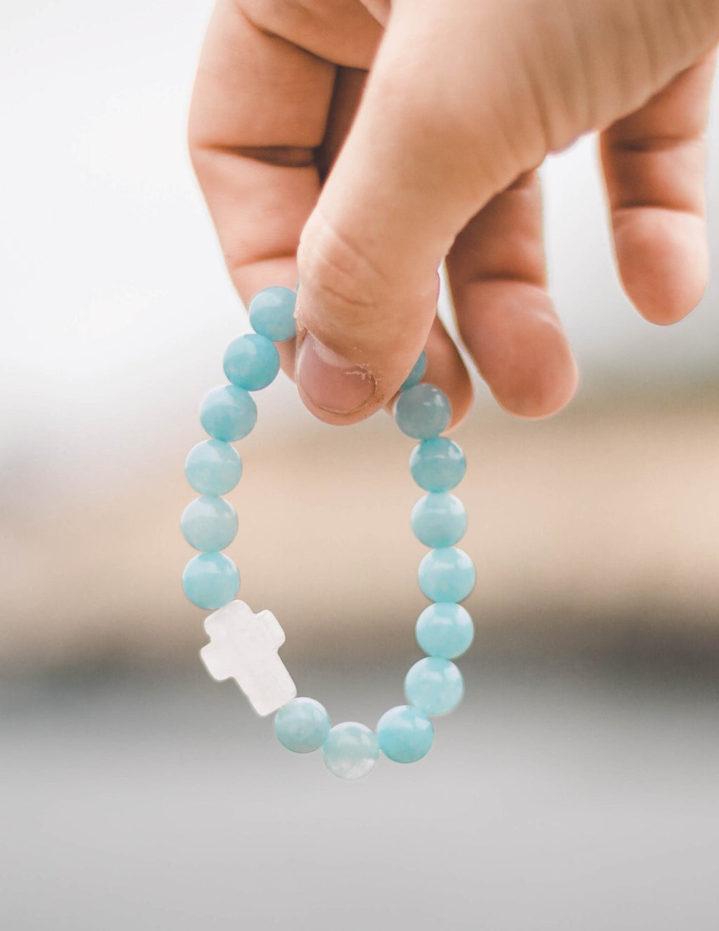 Elevated Faith Christian Jewelry Bracelet featuring blue stone beads and a white cross charm