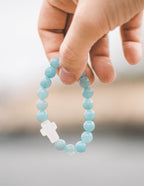 Elevated Faith Christian Jewelry Bracelet featuring blue stone beads and a white cross charm
