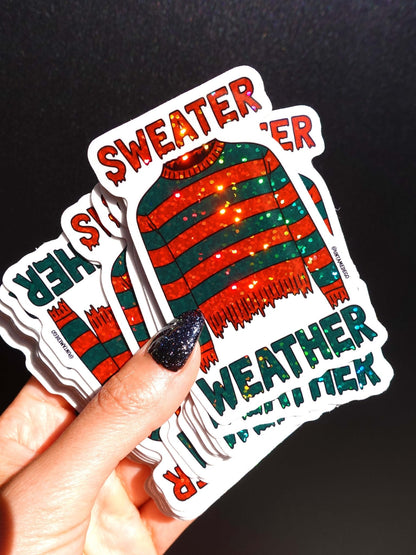Funny Sweater Weather horror sticker, striped red and green sweater with SWEATER and WEATHER text