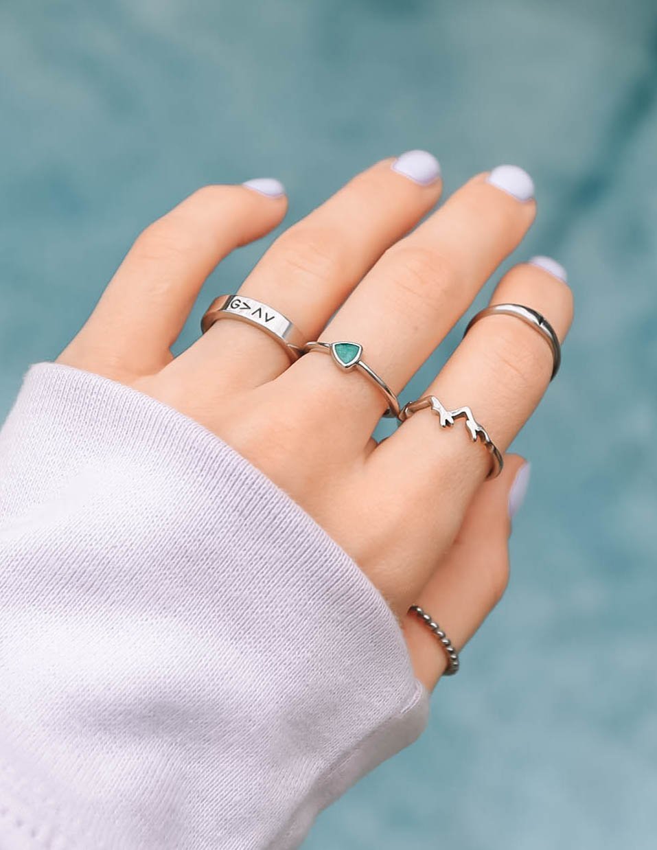 Trendy collection of Elevated Faith rings showcasing Christian Jewelry placed on a hand