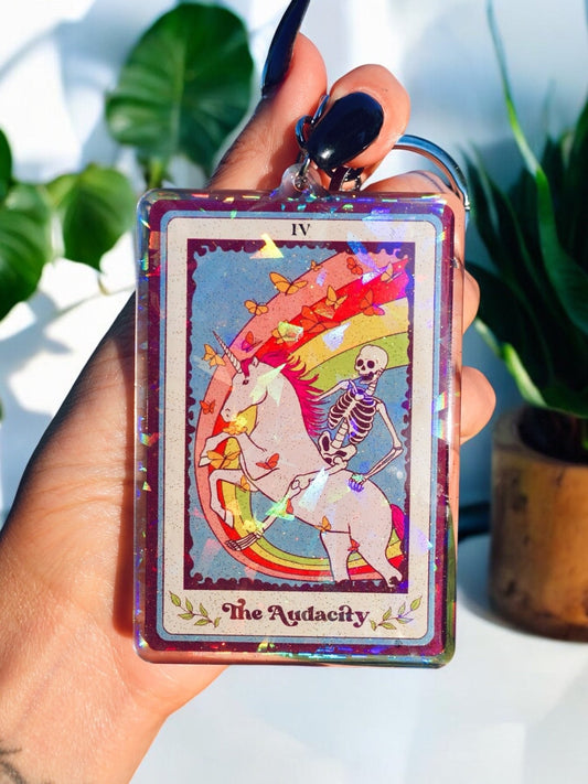 Funny Holographic keychain with 'IV' card art: 'The Audacity' skeleton figure