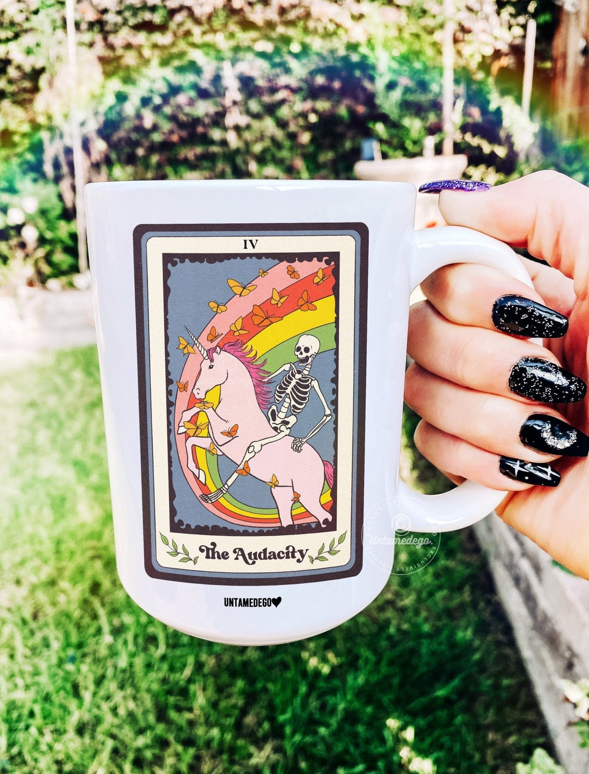 Funny "The Audacity Tarot" — Hand holding white ceramic tarot mug with colorful 'IV' The Audacity card graphic