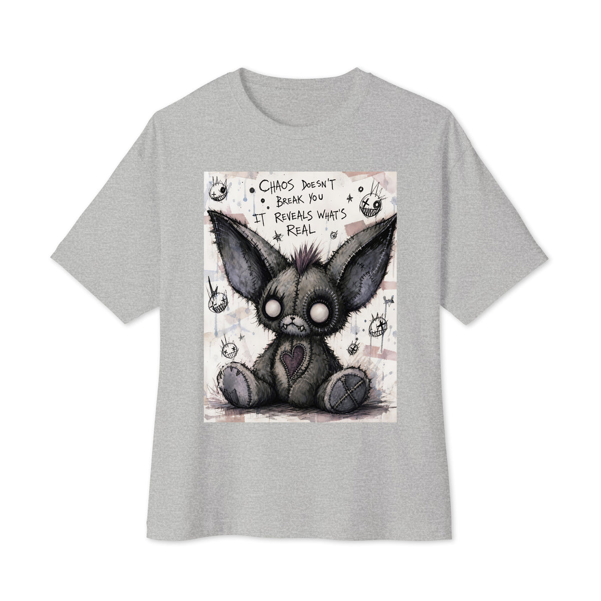 Athletic heather oversized boxy tee with the 'Chaos' goth graphic: a stitched gray big-eared creature with button eyes, with the words "Chaos doesn't break you, it reveals what's real"