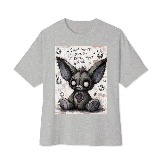 Athletic heather oversized boxy tee with the 'Chaos' goth graphic: a stitched gray big-eared creature with button eyes, with the words "Chaos doesn't break you, it reveals what's real"