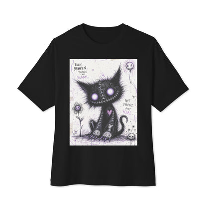 Black oversized boxy tee with the 'Even Broken Things Can Bloom' goth graphic: a stitched black cat with glowing purple eyes beside a flower, with the words "Even broken things can bloom"