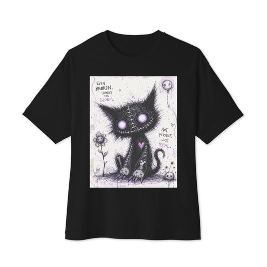 Black oversized boxy tee with the 'Even Broken Things Can Bloom' goth graphic: a stitched black cat with glowing purple eyes beside a flower, with the words "Even broken things can bloom"