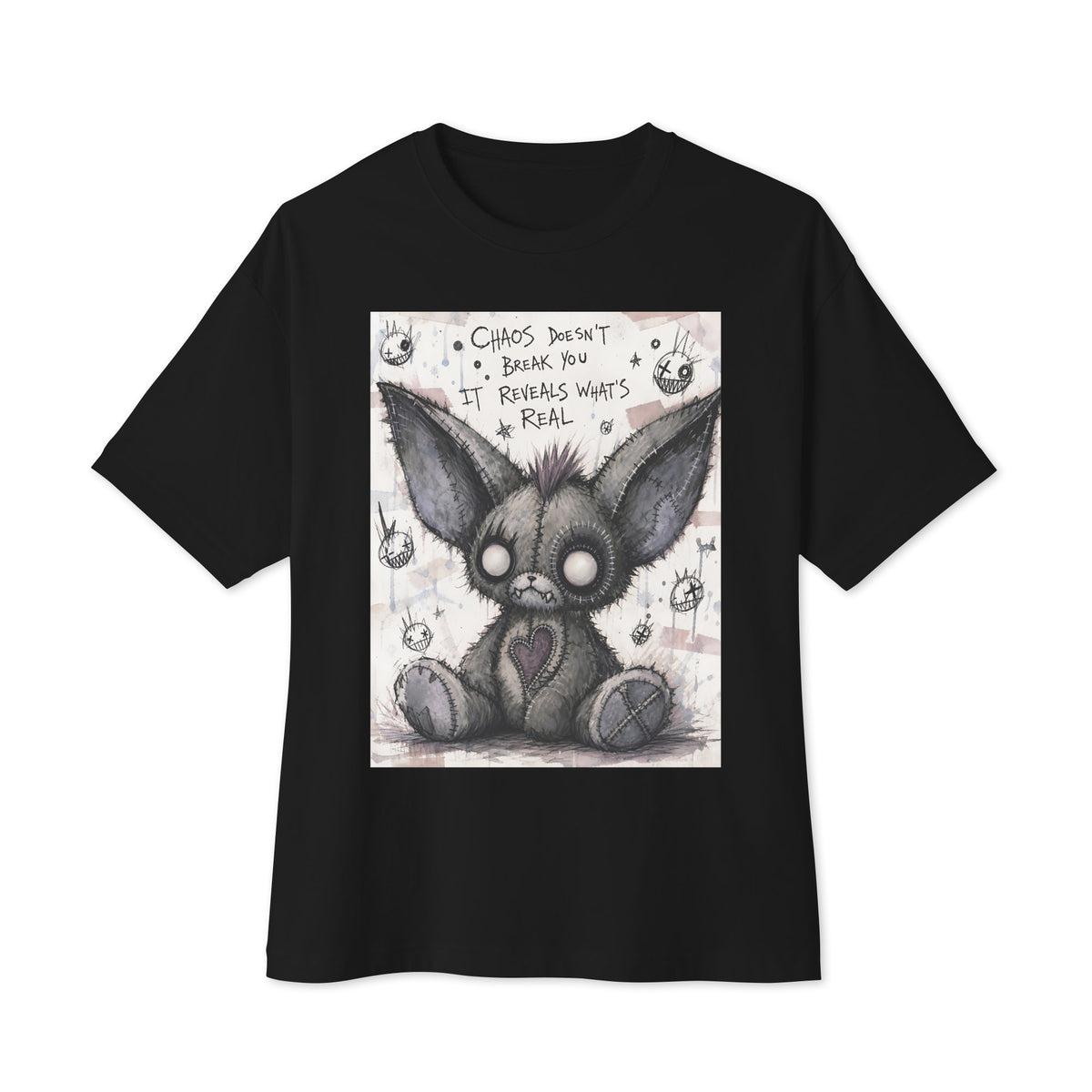 Black oversized boxy tee with the 'Chaos' goth graphic: a stitched gray big-eared creature with button eyes, with the words "Chaos doesn't break you, it reveals what's real"