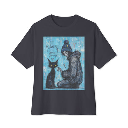 Dark grey oversized boxy tee with the 'Kindness Is Never Wasted' goth graphic: a girl in a moon beanie petting a black cat on a blue background, with the words "Kindness is never wasted"
