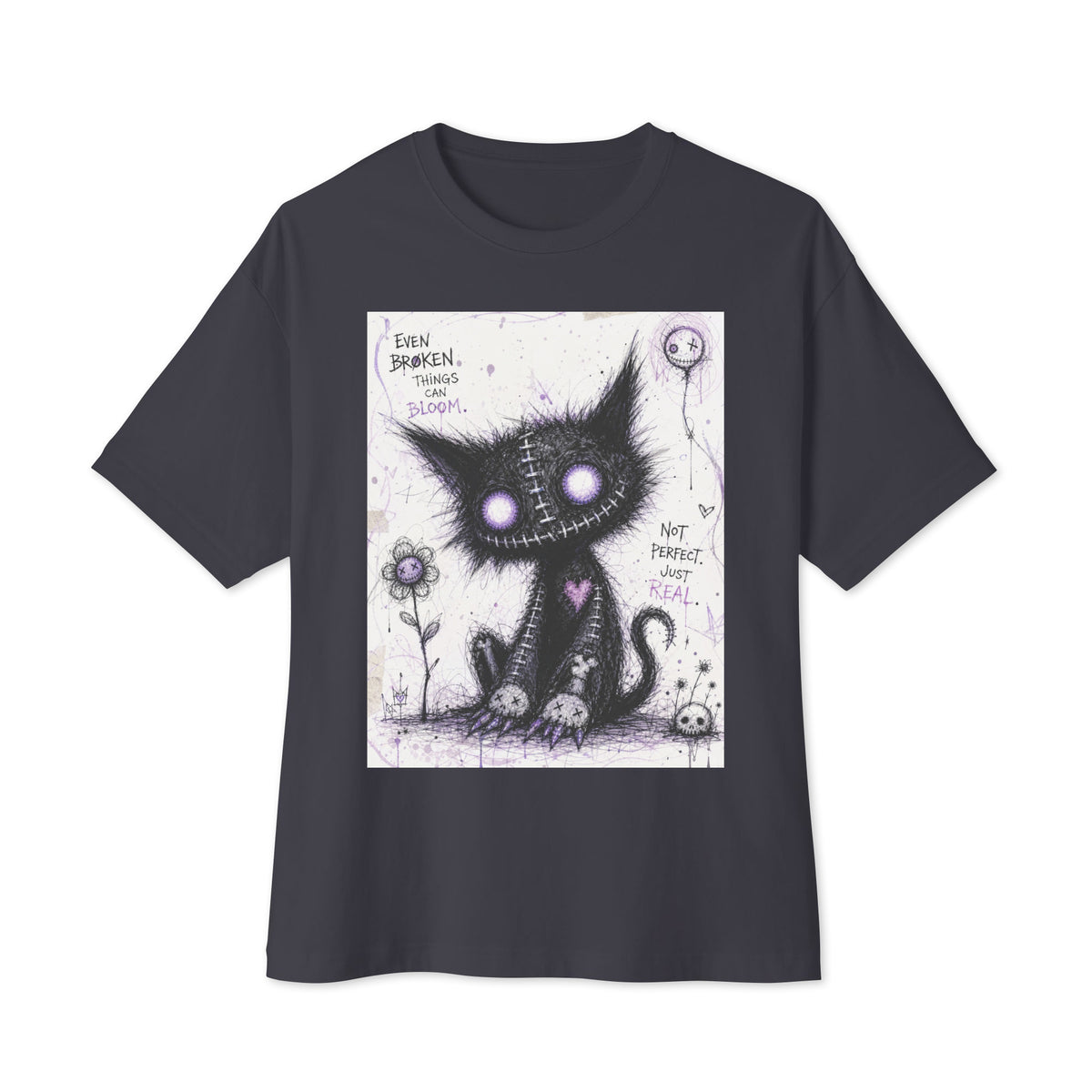 Dark grey oversized boxy tee with the 'Even Broken Things Can Bloom' goth graphic: a stitched black cat with glowing purple eyes beside a flower, with the words "Even broken things can bloom"